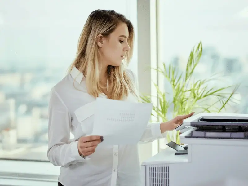 Confident businesswoman tackles printing task with efficiency